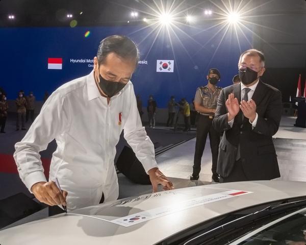조코 위도도 인도네시아 대통령(왼쪽)이 2022년 3월 16일 인도네시아 브카시 현대차 인도네시아공장 준공식에서 아이오닉 5에 서명하고 있다. 오른쪽은 박수치는 정의선 현대차그룹 회장.